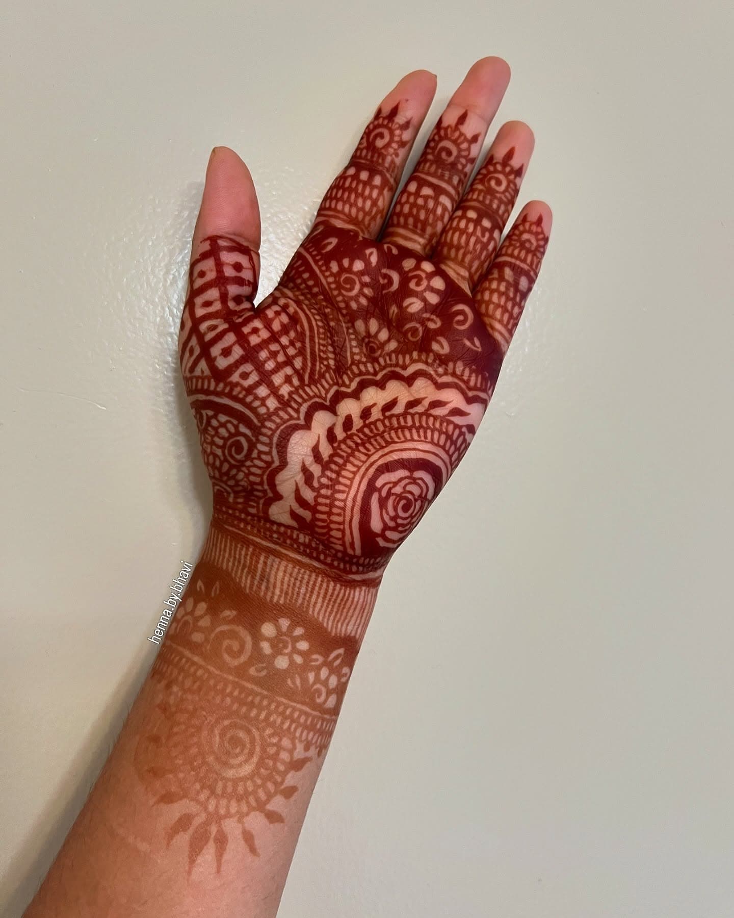 A deeply stained palm filled with a mandala and a scalloped floral border