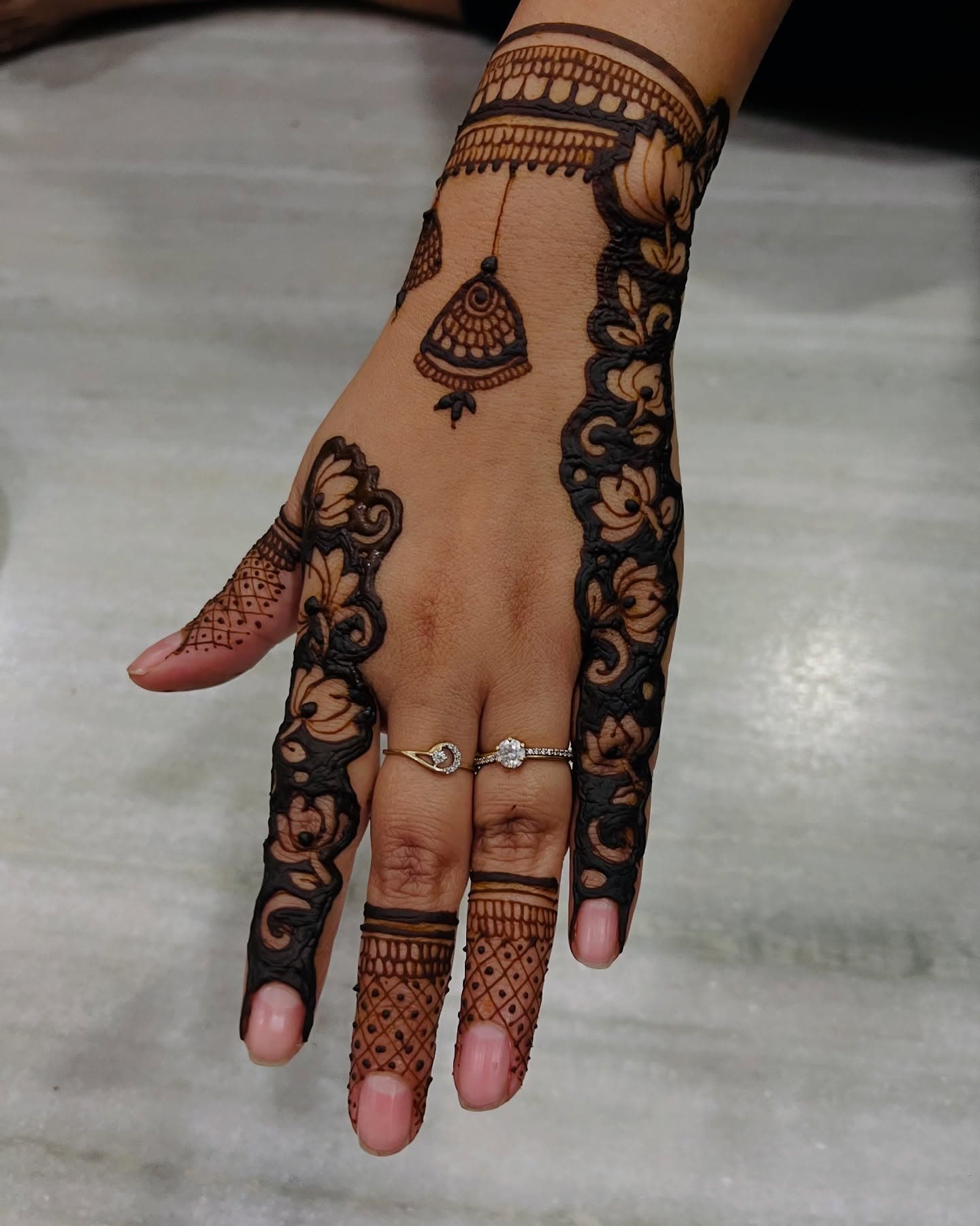 A chandelier jhumka motif drawn down the back of a hand